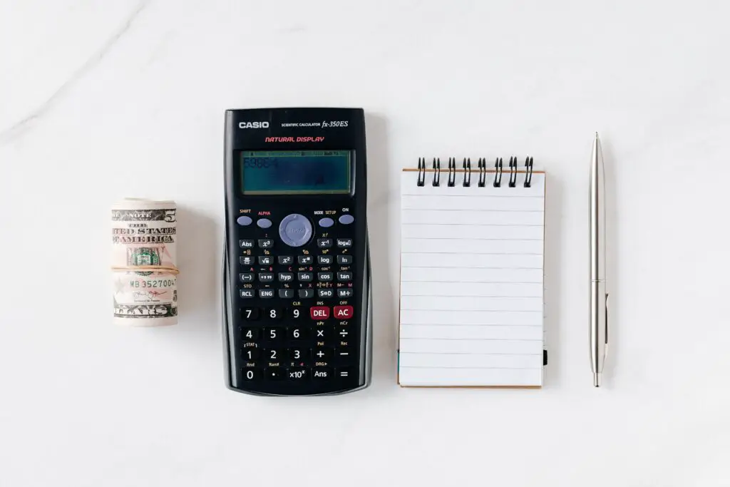composition-of-calculator-with-paper-money-and-notebook-with-pen