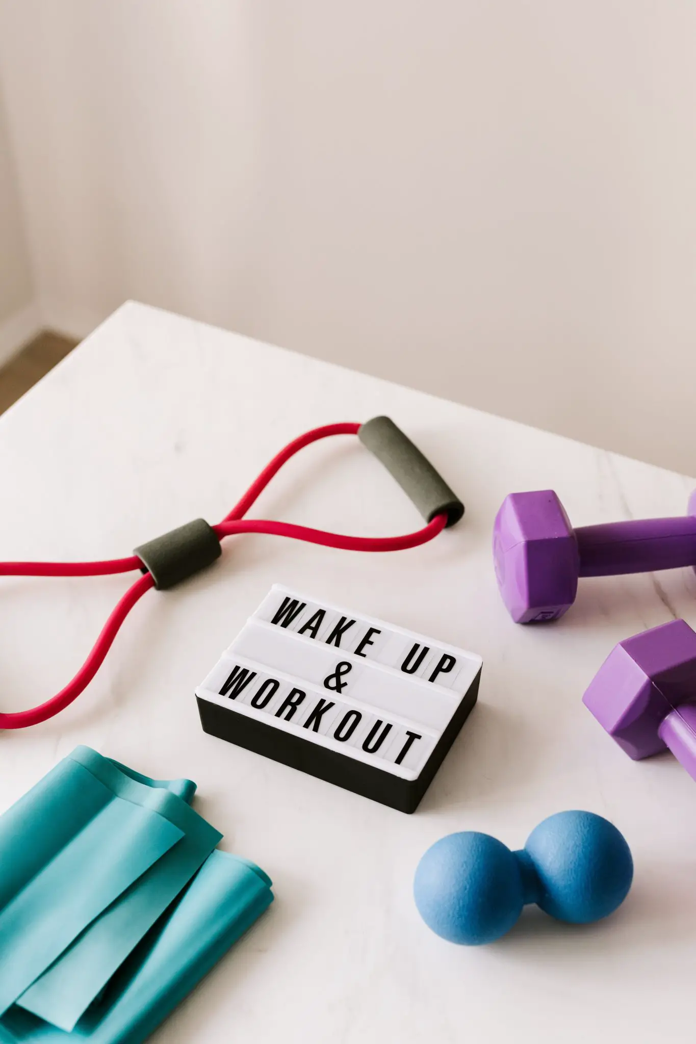 wake-up-and-workout-slogan-on-light-box-among-sports-equipment