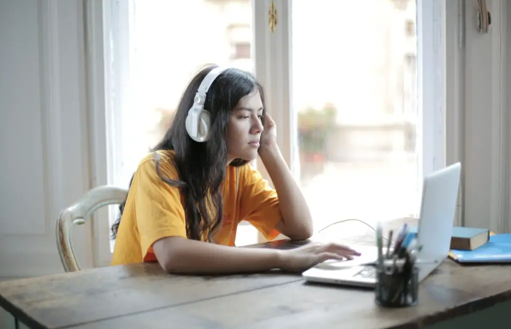 woman-in-yellow-shirt-wearing-white-headphones