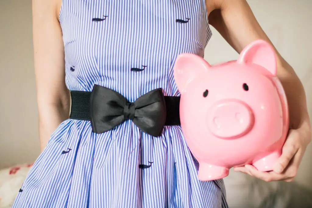 crop photo of girl holding piggy bank