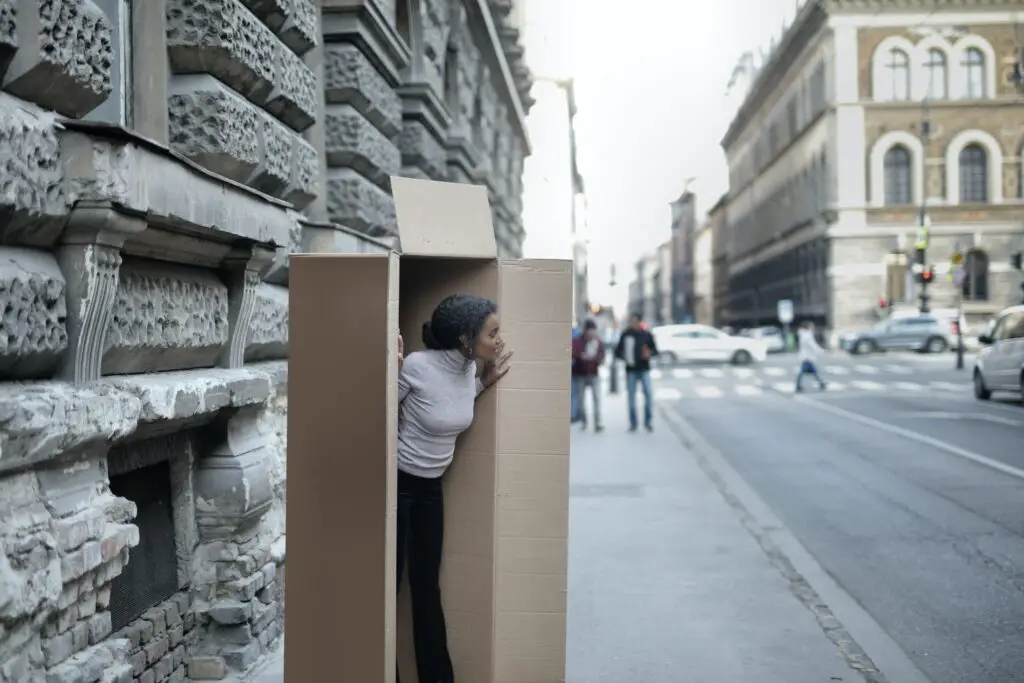 best side hustles for introverts african-american-woman-peeking-out-of-cardboard-box-on-sidewalk