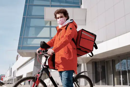 best side hustles for introverts delivery-man-wearing-a-face-mask-and-riding-a-bicycle