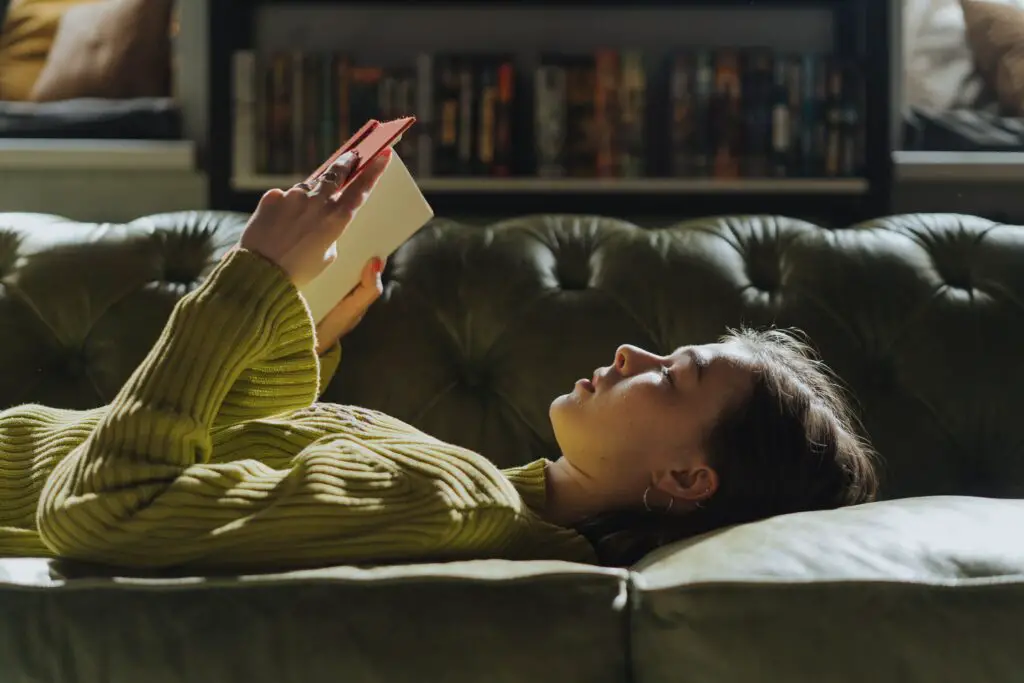 woman-in-yellow-long-sleeve-shirt-lying-on-couch