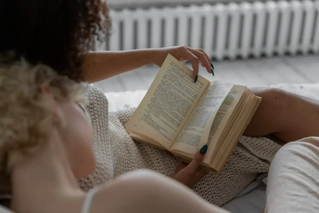 woman-reading-book-on-white-textil