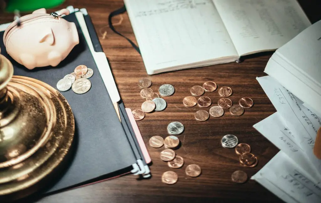 coins-scattered-on-desk-with-papers-and-creative-pig-wallet