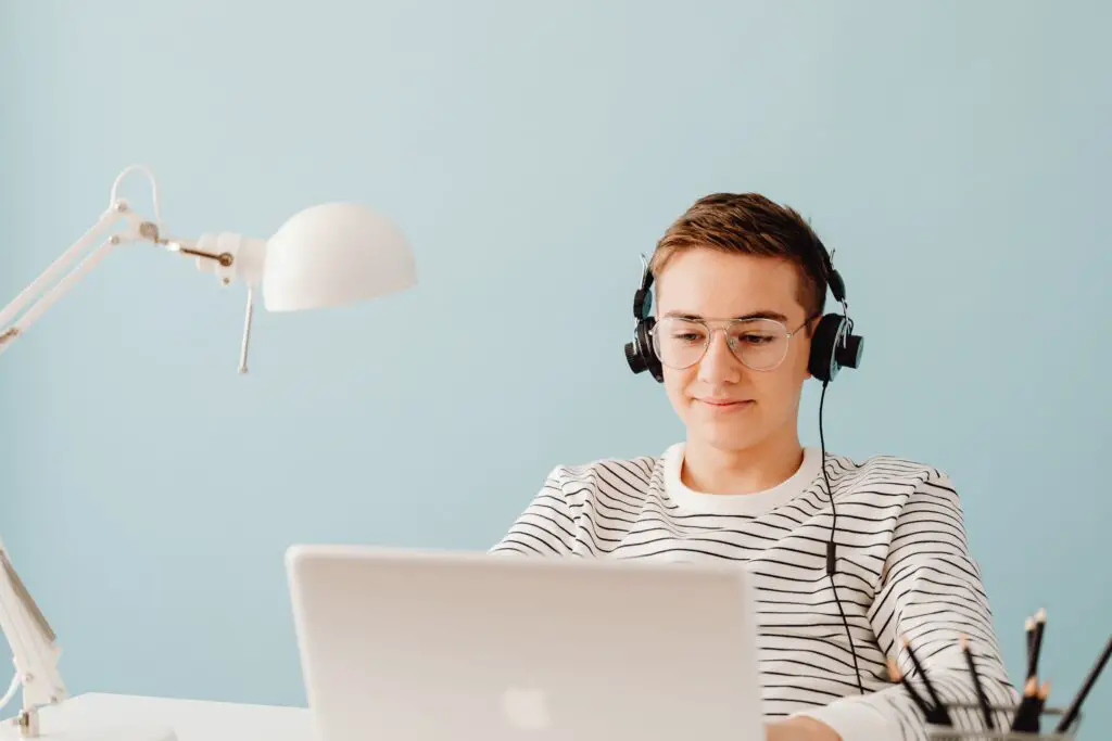 transcribe anywhere review photo of a man typing on laptop with headphone
