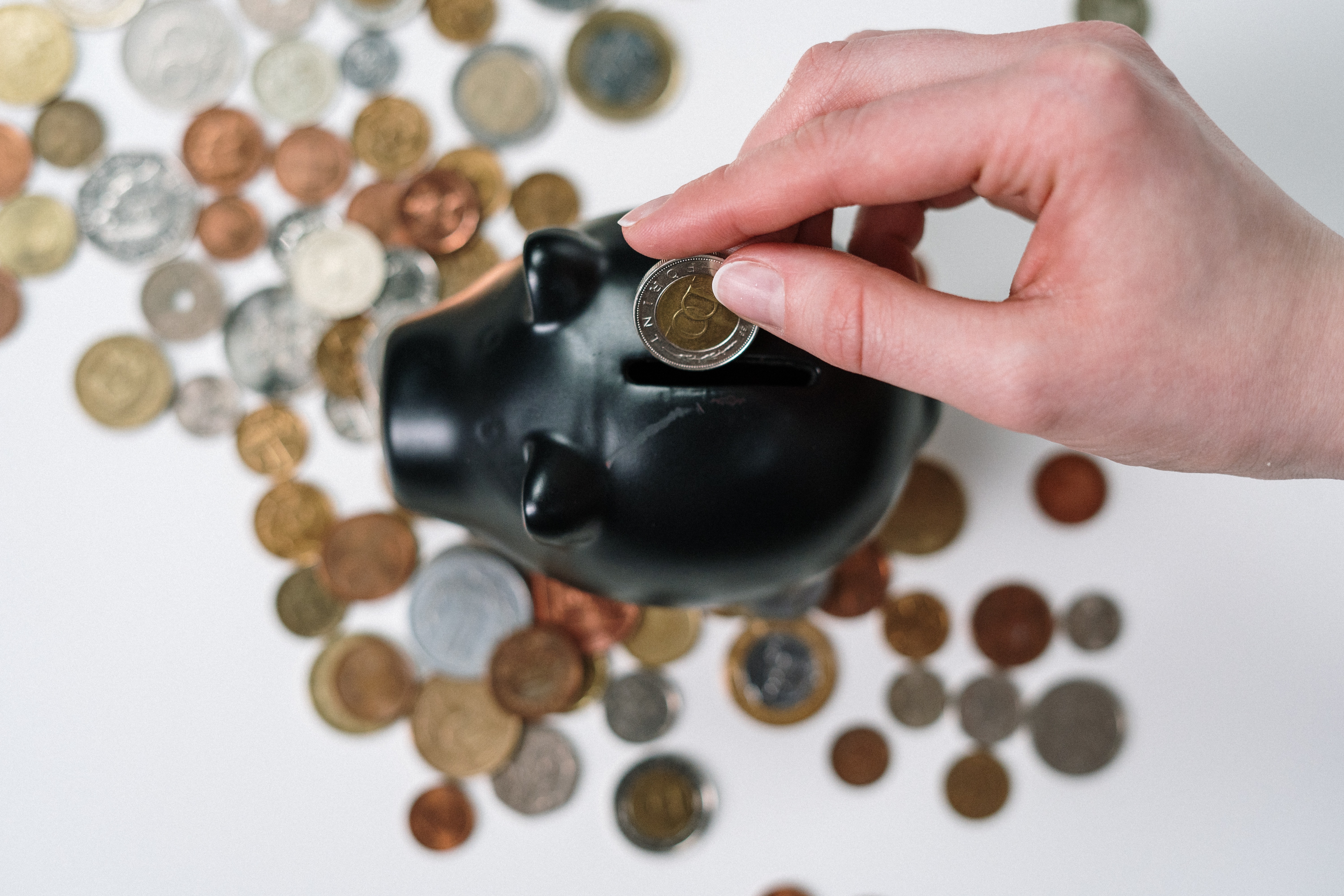 person putting coin in a piggybank